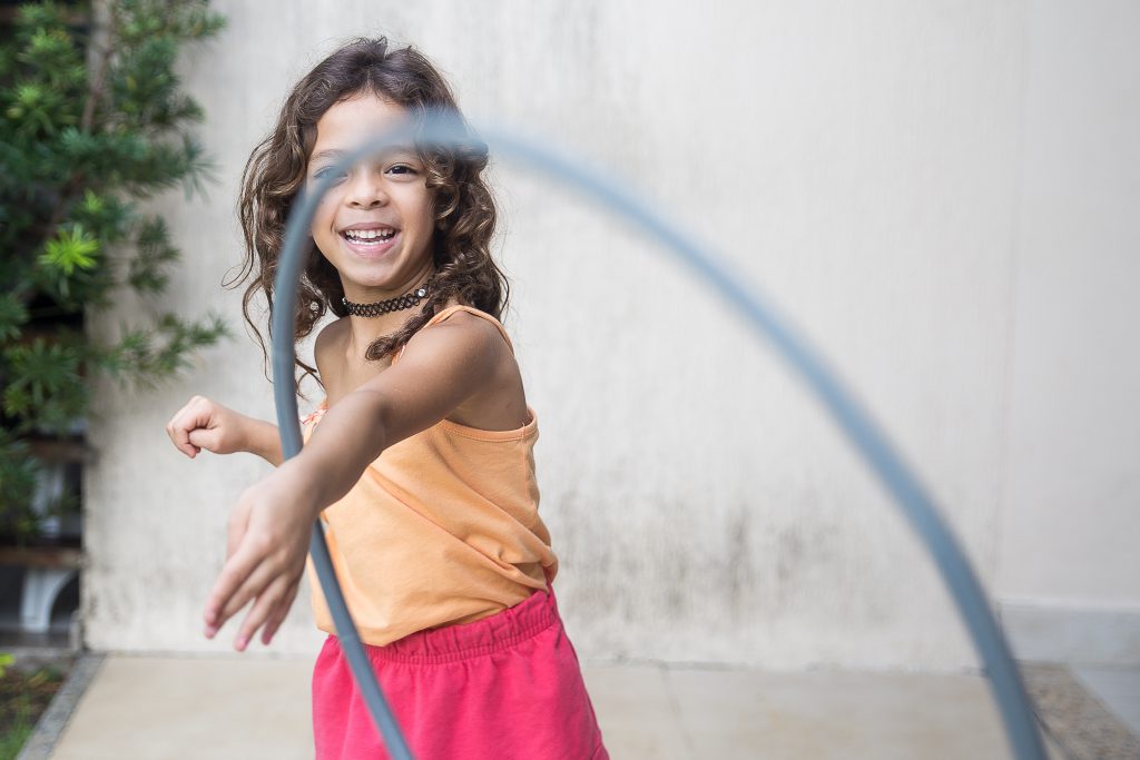 Girl spinning hula hoop around her arm